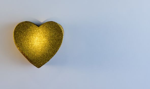 Sparkly heart of gold on white background