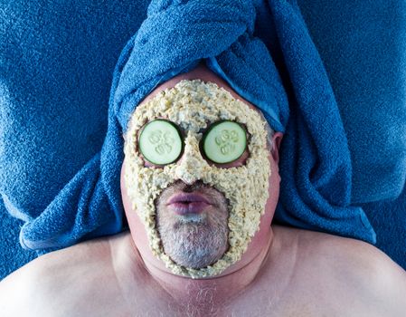 Man with silly facial expression receiving a facial at the spa