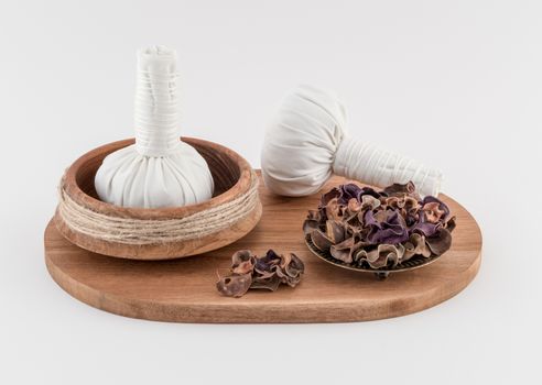 Thai herbal massage balls with dried herbs on wooden board