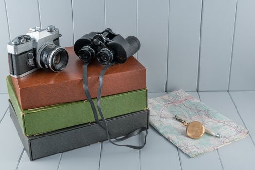 Vintage camera and binoculars still life on gray wood plank background
