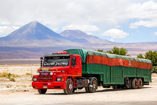 SAN PEDRO DE ATACAMA, CHILE - NOVEMBER 15, 2015: Semi-trailer truck Scania T at the background of a volcano.
