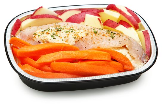 Raw Prepared Crab Stuffed Tilapia with carrots and potatoes Ready for the Oven. Isolated on white.