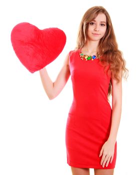 Portrait of a young attractive woman with a heart-shaped pillow isolated over white background