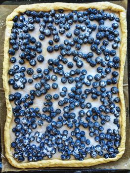 Fresh pie with blueberries and sugar, ready for baking.