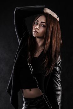 Beautiful young woman with a chain over black background