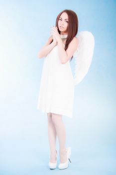 Beautiful young angel over cyan background