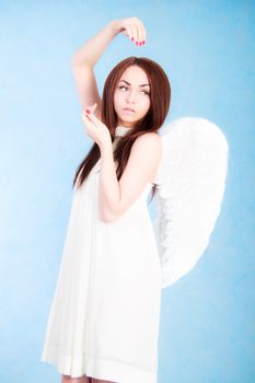 Beautiful young angel over cyan background