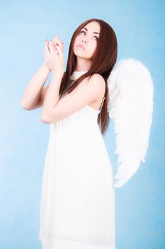 Beautiful young angel over blue background