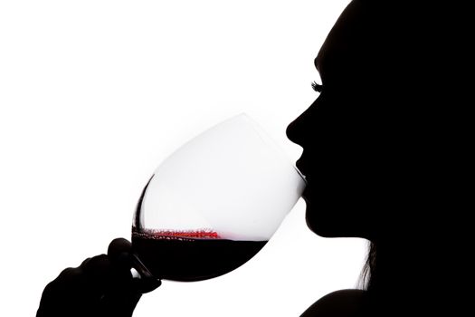 Silhouette of a woman drinking the wine