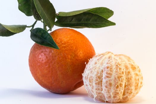 Tangerine and peeled tangerine on white background.