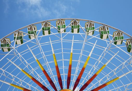 Fragment of a ferris wheel against clear blue sky