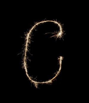 Letter C drew with spakrs on a black background.