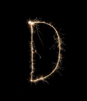 Letter D drew with spakrs on a black background.
