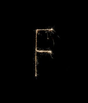 Letter F drew with spakrs on a black background.