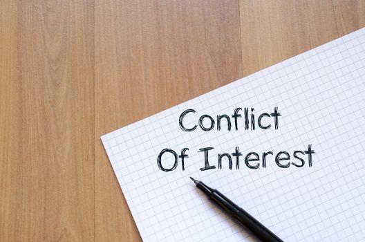 Conflict of interest text concept write on notebook with pen