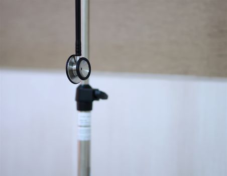 Black stethoscope was hanging on medical stand in patient room.