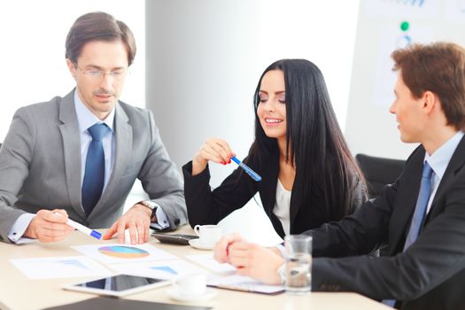 Workers at business meeting looking at presentation of financial reports in modern office