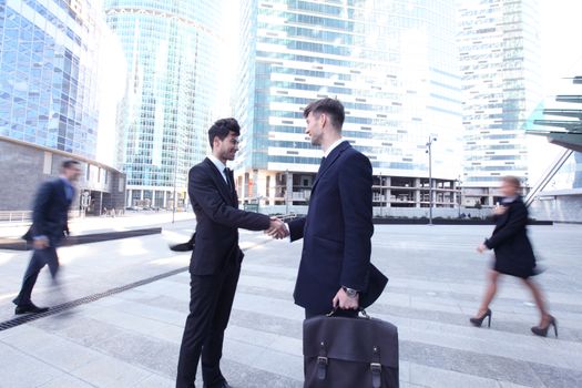 Business people shaking hands, finishing up a meeting outside office