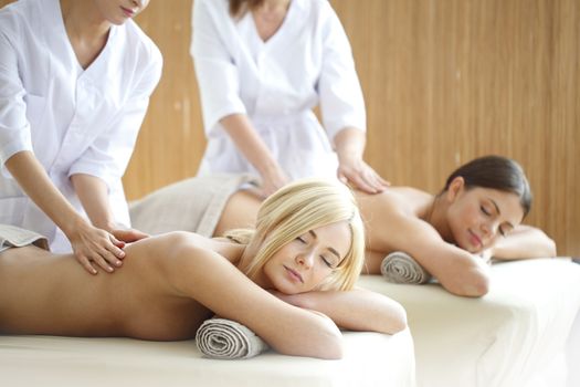 Two beautiful women getting massage in spa