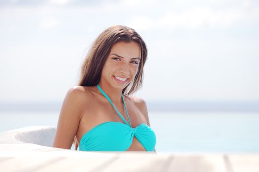 Beautiful woman relaxing at swimming pool at tourist resort