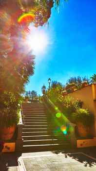 Brown concrete stair in city garden. The sun is shining into the lens