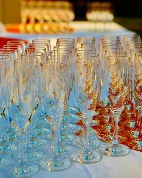 Empty wine glasses arranged in row, setup for wedding ceremony.