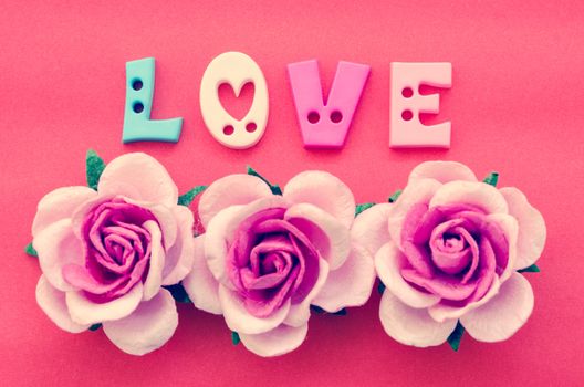 Vintage pink roses flower and love text on red background.