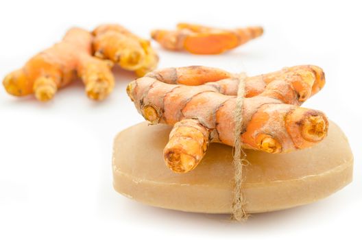 Soap made of turmeric with fresh turmeric on white background.