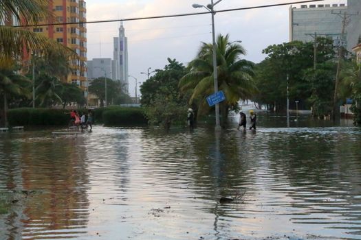 CUBA, La Havana: CUBA, La Havana: People wade through a flooded street named Avenida de los Presidentes in La Havana, Cuba, on January 17, 2016. Heavy seas invaded the Havana coastline along the Malecon seawall. 