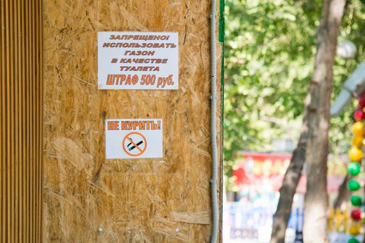 Two ads on the wall "Use a lawn as a toilet-smoking" and "no smoking" sign with a crossed-out cigarette