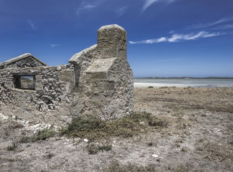 Ruins of a historic house right by the sand of a beautiful beach and wetlands