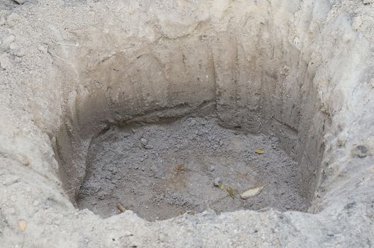 Close up big hole dug for planting tree in garden.