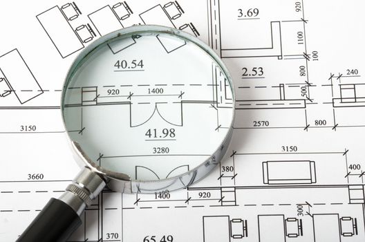 Magnifier on blueprints with numbers, close up view