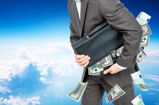 Businessman with suitcase full of money in sky