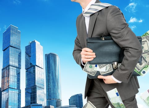 Businessman with suitcase full of money and city background