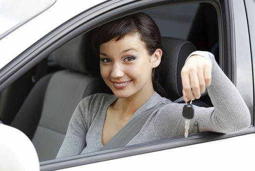 Pretty girl in a car showing the key