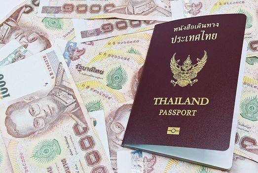 Thailand passport with Thai money ready to travel on white background
