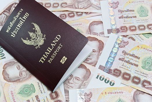 Thailand passport with Thai money ready to travel on white background