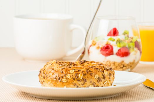 Fresh made muesli bagel with coffee and fruit.