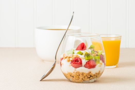 Delicious fruit and yogurt parfait served with coffee and juice.