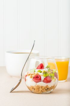 Delicious fruit parfait served with coffee and orange juice.