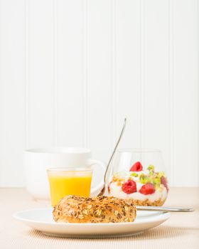 Fresh muesli bagel with coffee and fruit.