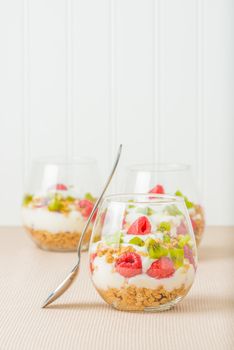 Glasses filled with parfait consisting of granola, yogurt and fresh fruit.