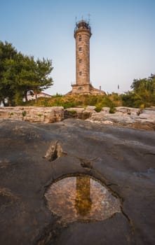 Savudrija Lighthouse on Rocky Coast Reflected in a Puddle, the Most Western Point of the Balkans Peninsula and the Oldest Lighthouse in Croatia (Built 1818)