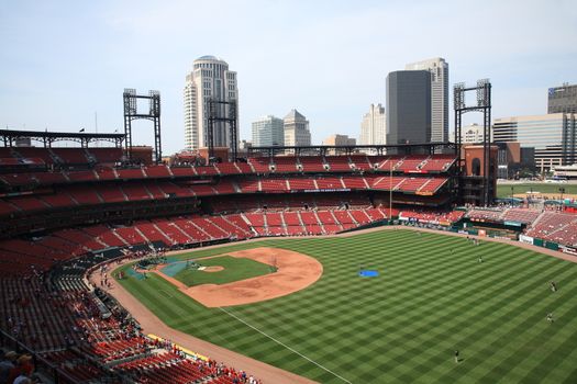 Fans gather for a late season Cardinals game at Busch Stadium, under the city skyline.