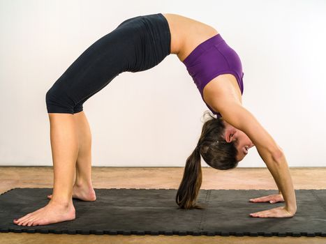 Photo of an attractive female in her 20's doing yoga stomach stretches.
