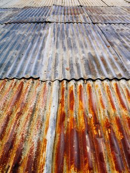 Photo of a rusty corrugated metal roof at an angle.