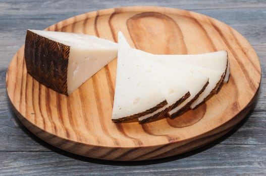 Wooden board with cheese cut into triangles
