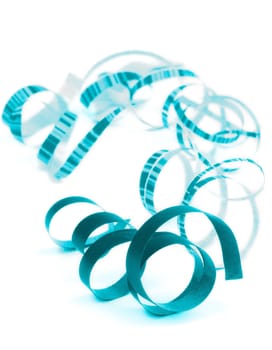 Arrangement of Blue and Striped Curled Party Streamers Lying on white background. Focus on Foreground