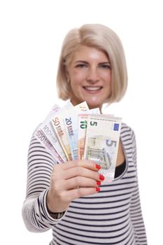 Attractive smiling blond woman holding up a handful of fanned Euro notes in different denominations, tilted angle conceptual image isolated on white